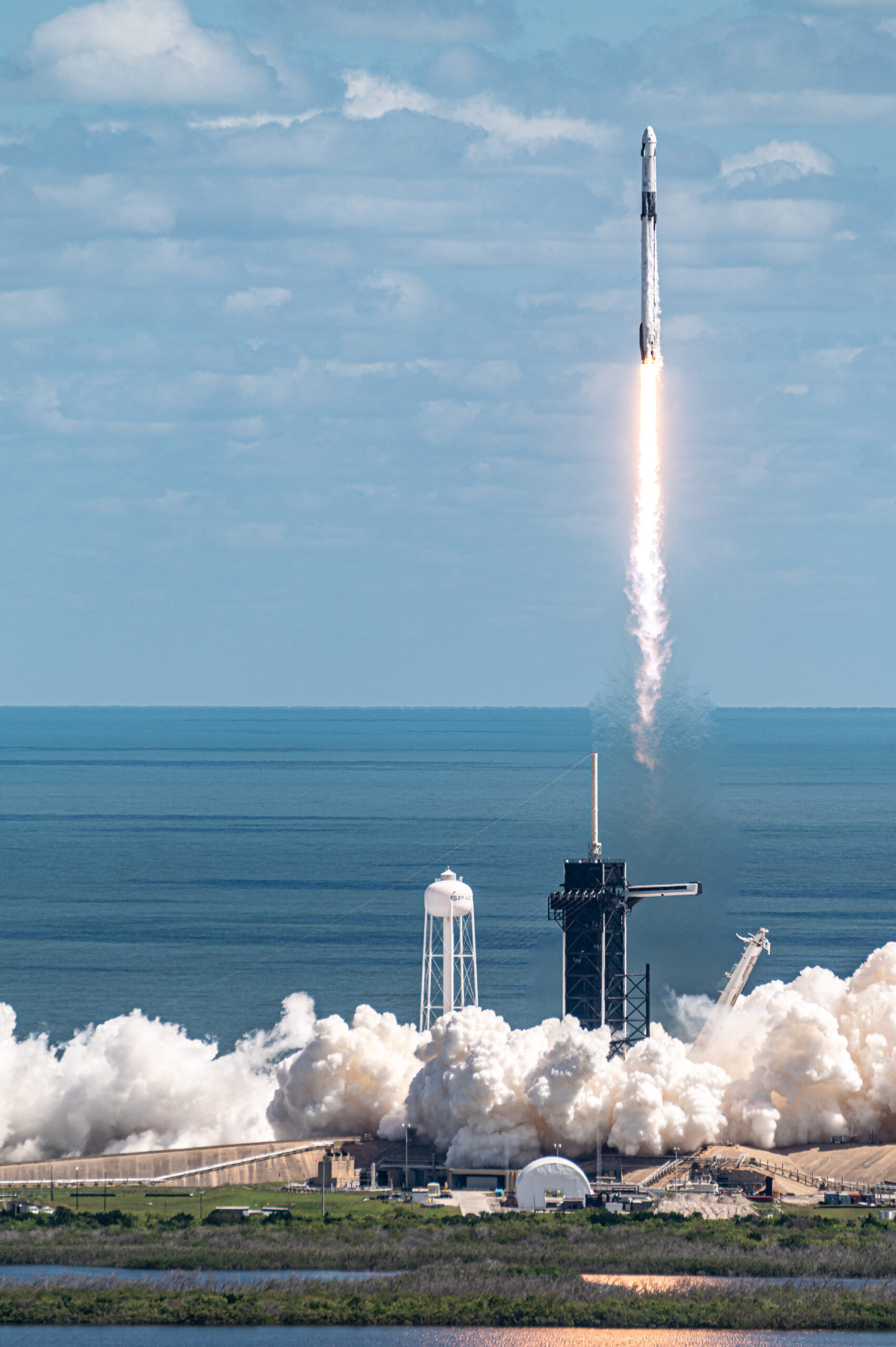 Falcon 9 clearing the tower at LC-39A with the plume engulfing the launch pad below.