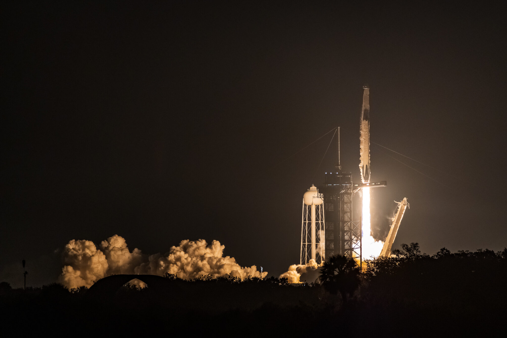 Close up of Falcon 9 lifting off from LC-39A with the plume illuminated by the rocket exhaust.